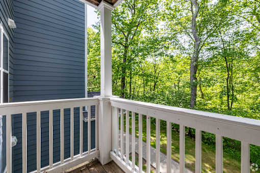 A view from a porch looking out at a wooded area.