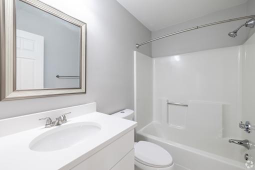 A white bathroom with a sink, toilet, and bathtub.