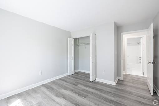 A room with a white door and a grey floor.