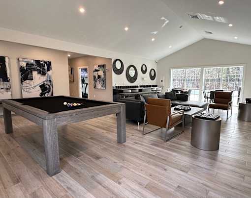 A billiard table is in the middle of a room with a black cloth on it.