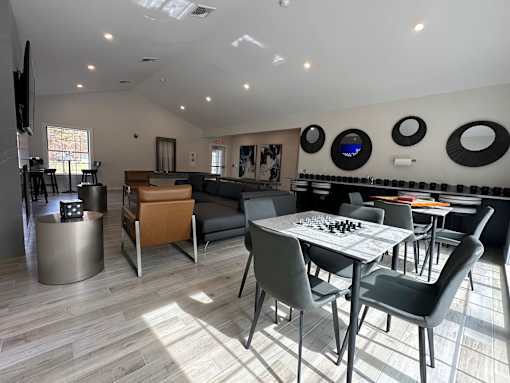 A room with a table and chairs and a television.