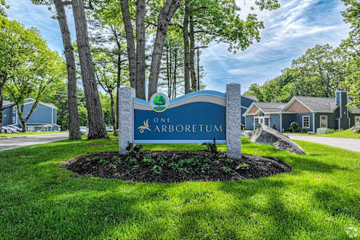A sign for Arboretum stands in a grassy area.