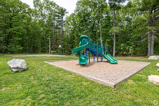 A playground with a green slide and a blue railing.