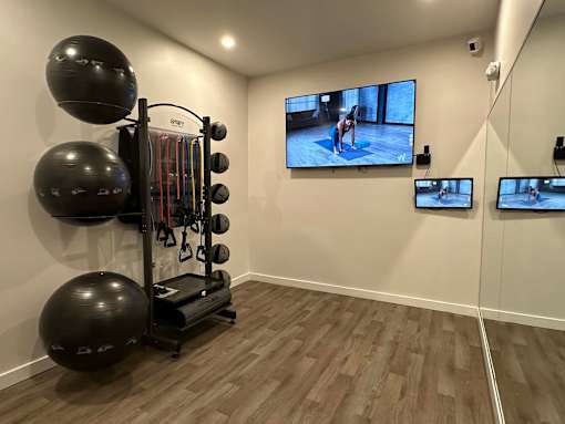 A home gym with a television screen showing a person exercising.