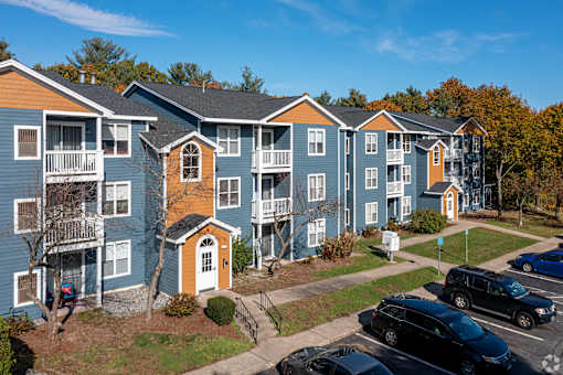 Apartment complex with cars parked in front.