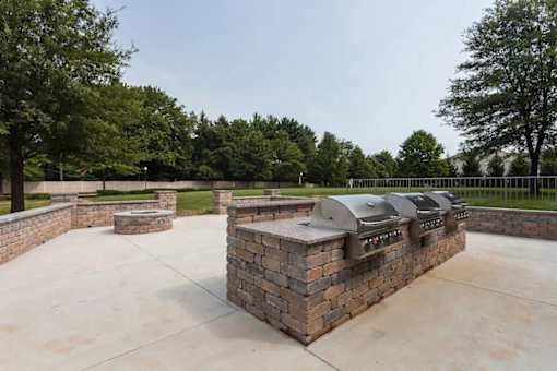 A series of outdoor grills are lined up on a patio.