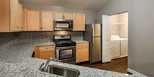 A kitchen with a stove, oven, refrigerator, and microwave.