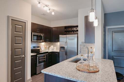 Kitchen with a granite countertop and stainless steel appliances at Caldwell, Houston