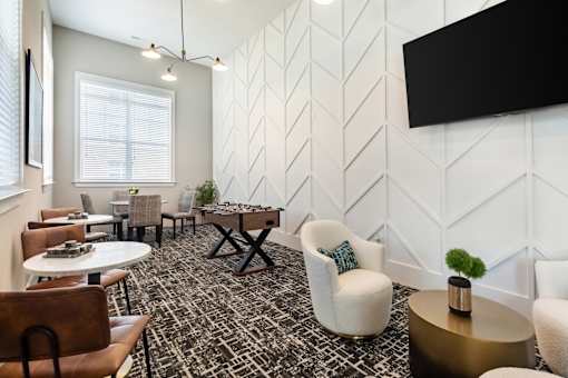 A modern lounge area with a patterned carpet and white walls.