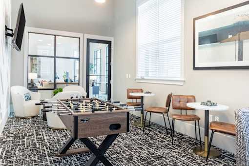 A foosball table is in the middle of a room with a black and white floor.