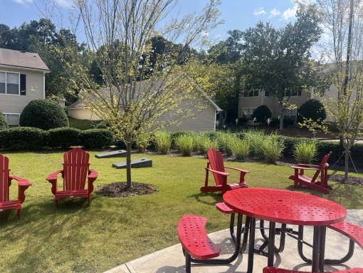 a patio with red chairs and a table in a yard at Addison on Cobblestone, Georgia