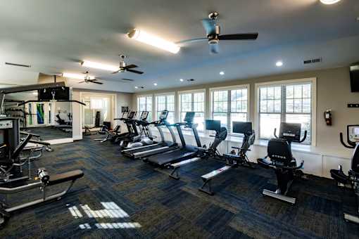 A gym with treadmills, elliptical machines, and other exercise equipment.