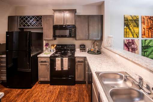A kitchen with a black refrigerator and stove.