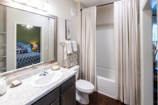 A bathroom with a white sink, toilet, and shower curtain.