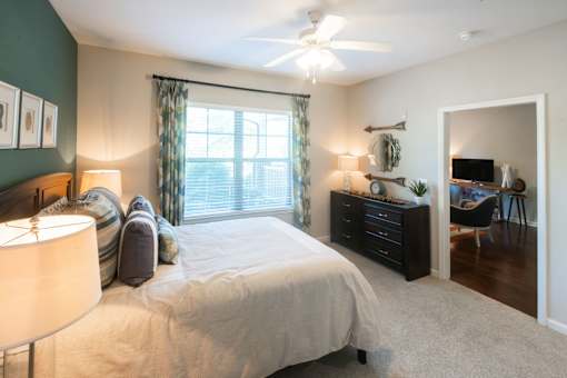 A bedroom with a bed, nightstand, and a ceiling fan.