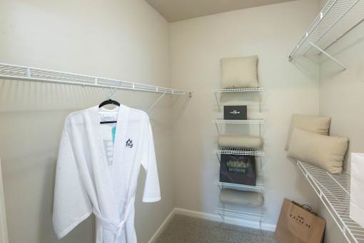 A white robe hanging on a rack in a room.