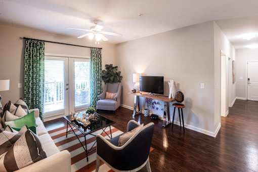 A living room with a striped rug and a black and white chair.