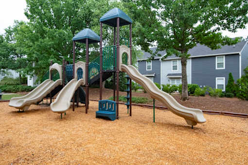 A playground with a brown slide and a green and blue structure.