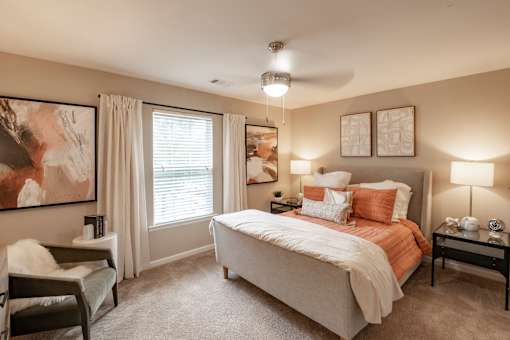A bedroom with a large bed and a ceiling fan.