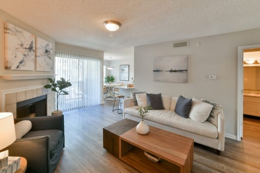 a living room with a couch coffee table and a fireplace at Arbors Harbor Town, Memphis, 38103
