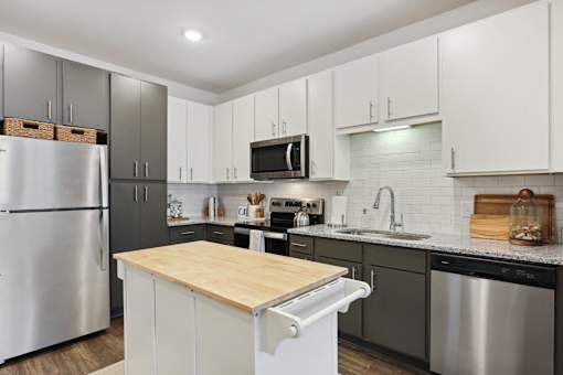 A modern kitchen with a wooden countertop and stainless steel appliances. at Arcadia Cartersville Apartments, Georgia, 30121