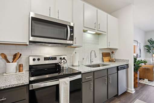 A modern kitchen with a black stove top oven and a microwave above it. at Arcadia Cartersville Apartments, Cartersville, GA, 30121