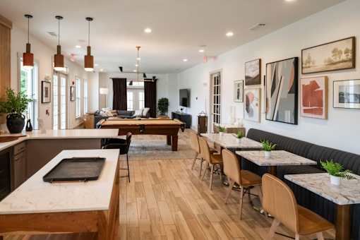 A modern kitchen and dining area with wooden floors and furniture at Ansley at Town Center Apartments, Evans