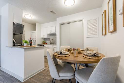 A modern kitchen with a dining table set for two. at Brightwaters Apartments, Little Rock, AR, 72202