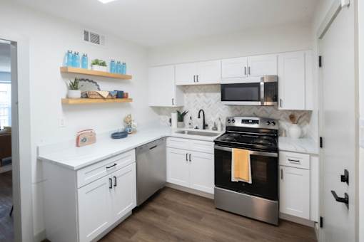 A kitchen with white cabinets and a black stove top oven. at Century Apartments, Memphis, 38117