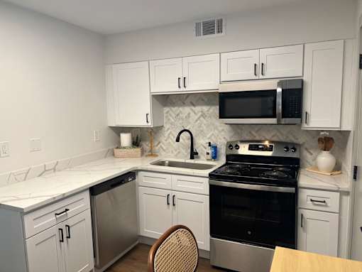 A kitchen with white cabinets and a black stove top oven.at Century Apartments, Memphis, 38117  
