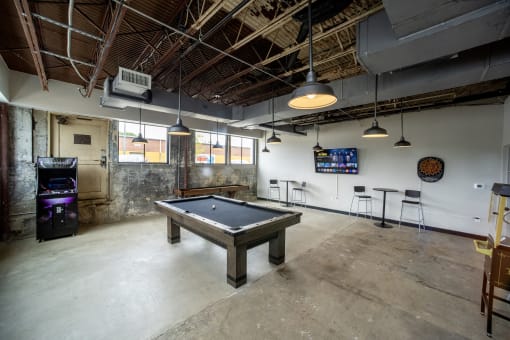a pool table sits in the middle of a room with a tv in the background