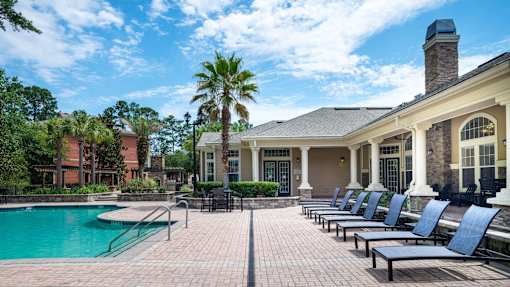 Pool deck with lounge chairs and clubhouse at Courtney Bend Apartments, Hardeeville, SC 29927