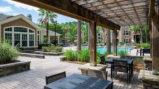 Covered pergola seating area with poolside views at Courtney Bend Apartments, Hardeeville