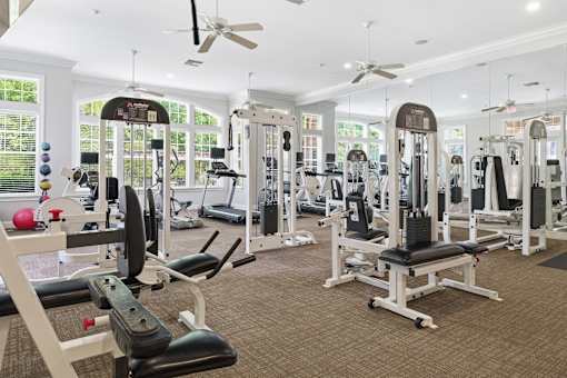 Strength training machines with cable systems and benches at Courtney Bend Apartments, South Carolina, 29927