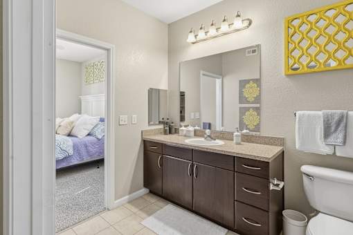 Bathroom vanity with large mirror and bedroom view at Courtney Bend Apartments, Hardeeville, South Carolina