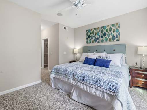 Master bedroom with teal headboard and carpeting at Courtney Bend Apartments, Hardeeville, South Carolina