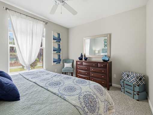 Bedroom with wood dresser and decorative mirror at Courtney Bend Apartments, Hardeeville