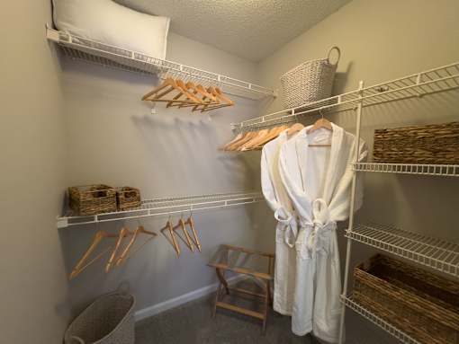 A white robe is hanging on a rack in a room at Enclave at Wolfchase Apartments, Memphis