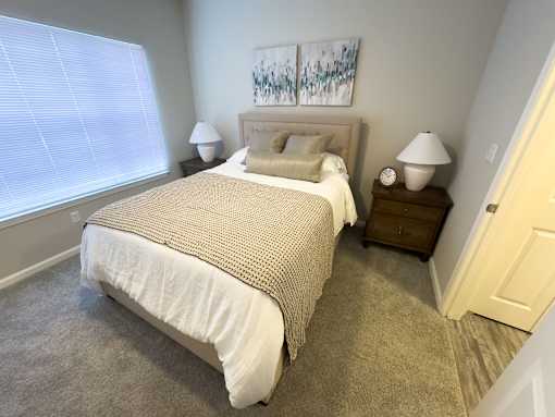 A bedroom with a large bed and two nightstands at Enclave at Wolfchase Apartments, Memphis, TN