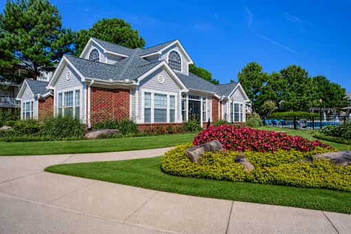 A house with a grey roof and a flower bed in front at Enclave at Wolfchase Apartments, Memphis, 38016