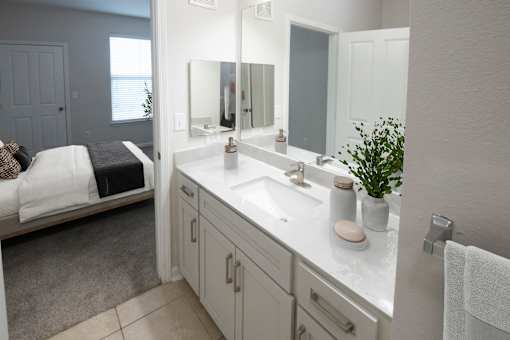 A white bathroom with a white sink and a white towel.