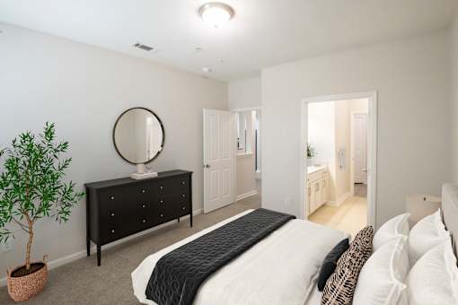 A bedroom with a large bed and a dresser with a mirror.