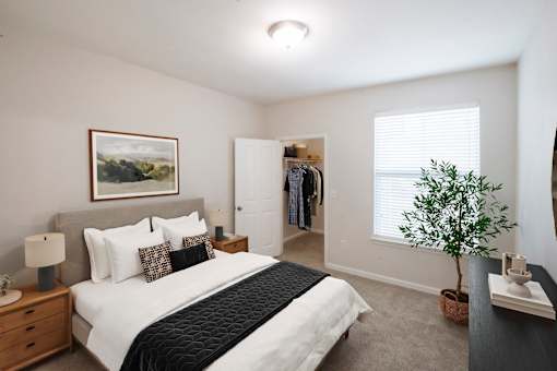 A bedroom with a large bed and a painting on the wall.