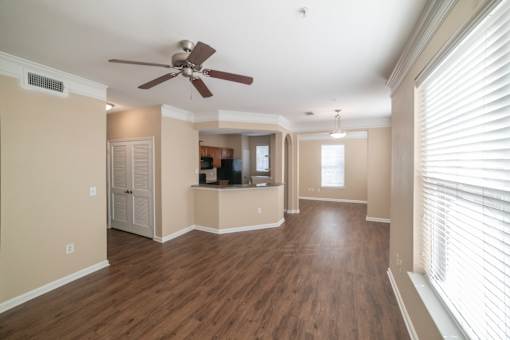 A room with a ceiling fan and wooden floors.