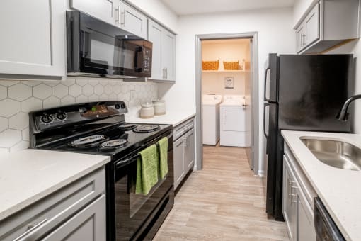 a kitchen with white cabinets and black appliances and a black refrigerator at 1900 Rosemont, Roswell, Georgia