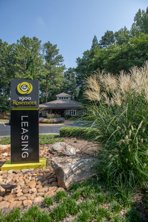 a sign at the entrance of a park with a creek