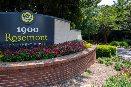 a brick retaining wall with a sign for rosenmont apartment homes