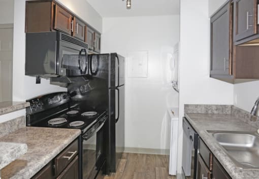 a kitchen with a stove and refrigerator and a sink at Brightwaters Apartments, Little Rock, AR,72202