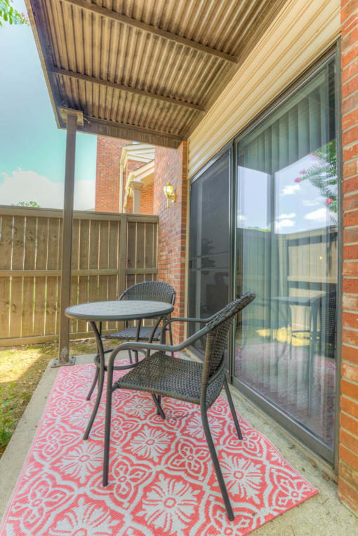 a patio with a table and chairs on a porch at Brightwaters Apartments, Little Rock, 72202