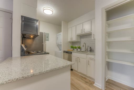a kitchen with granite counter tops and a stainless steel refrigerator at Brightwaters Apartments, Little Rock, Arkansas